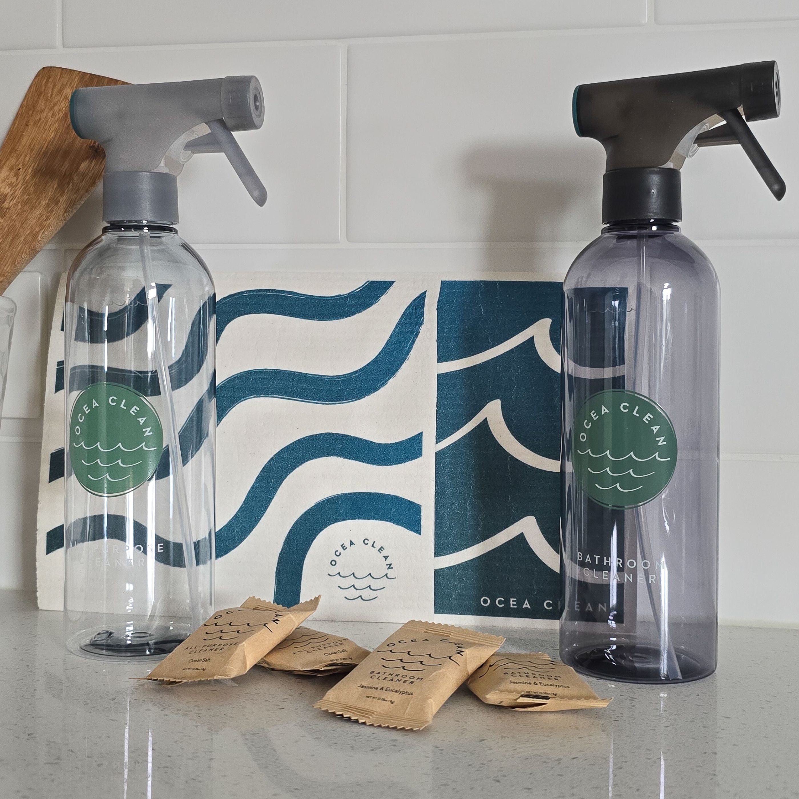 Two Ocea Clean spray bottles on a countertop with packaging and packets.