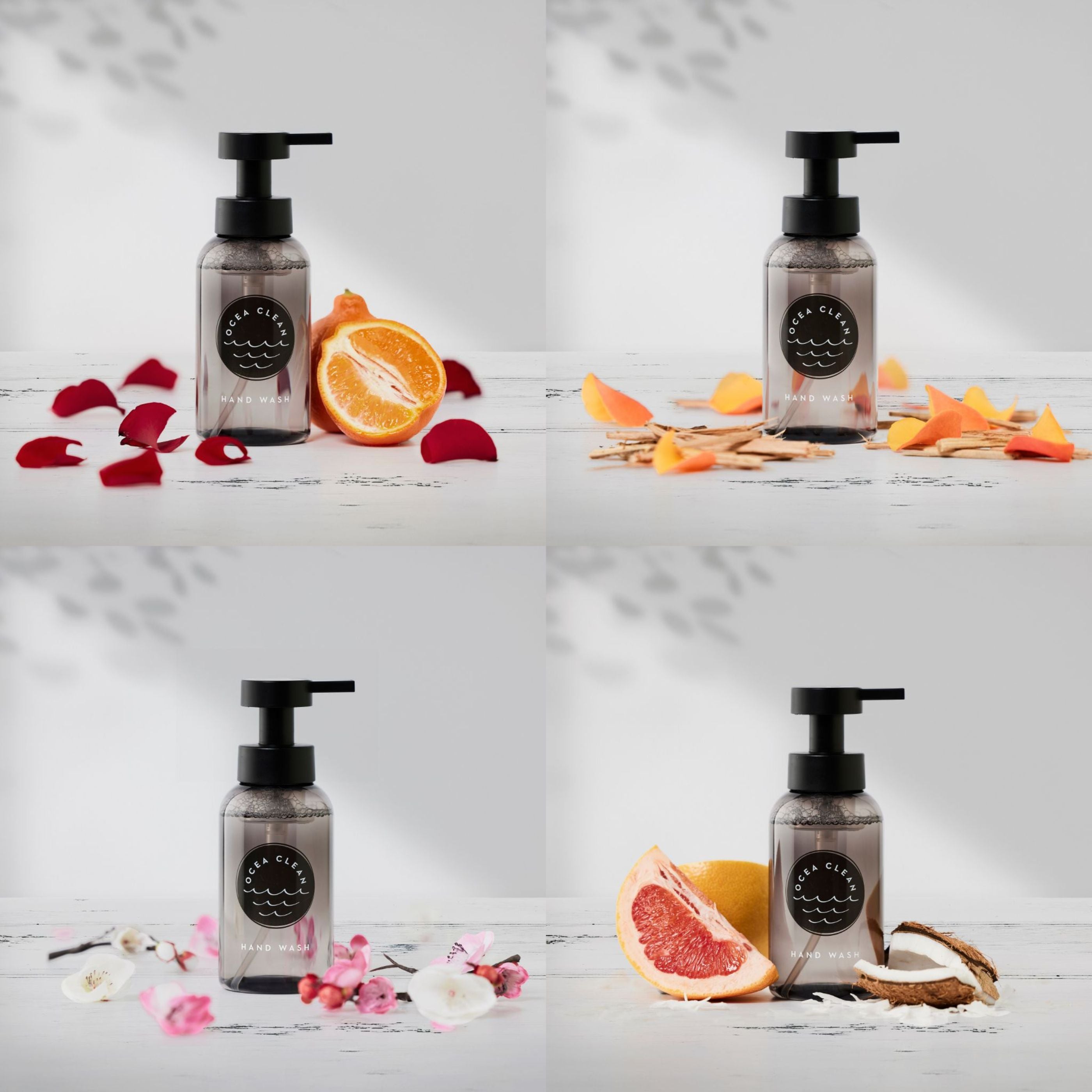 Four bottles of a skincare product with pump dispensers on a white surface with fruits and flowers.