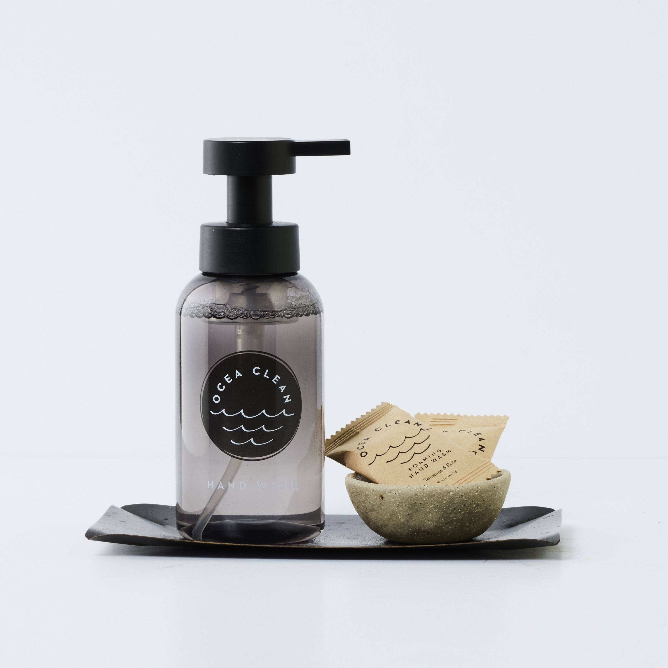 Clear soap dispenser with black pump and 'Ocea Clean' label on a white background